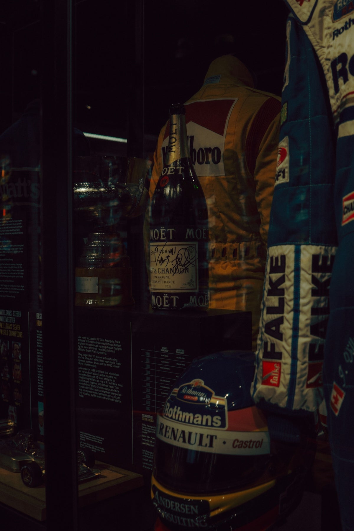 Champagne bottle and racing helmet on display